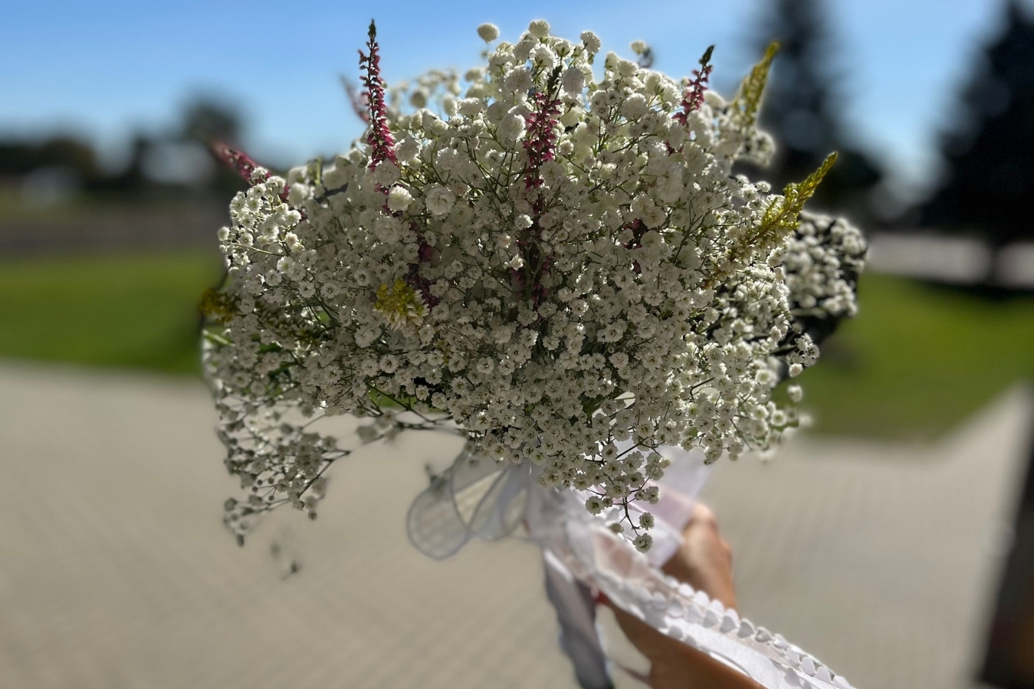 Duży bukiet ślubny z gipsówki z fioletowymi i żółtymi akcentami.